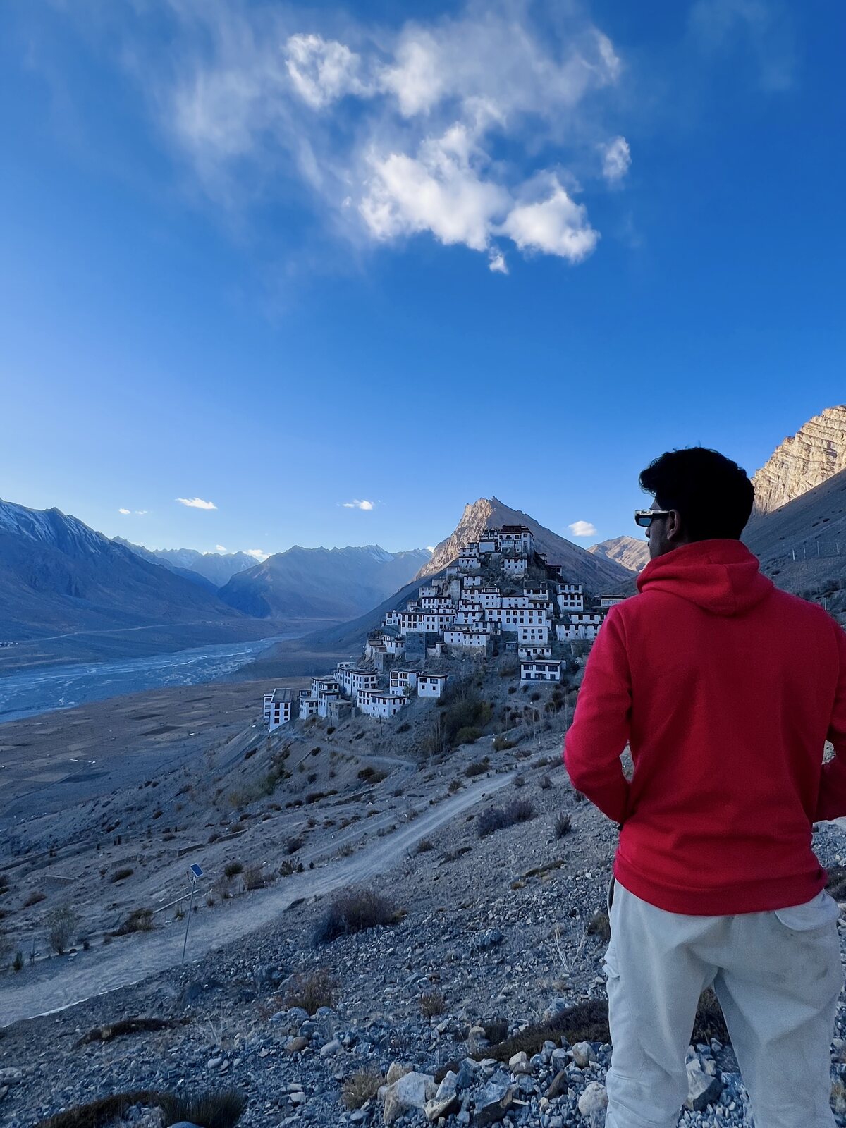 Traveller in a red hoodie looking out towards Key Monastery
