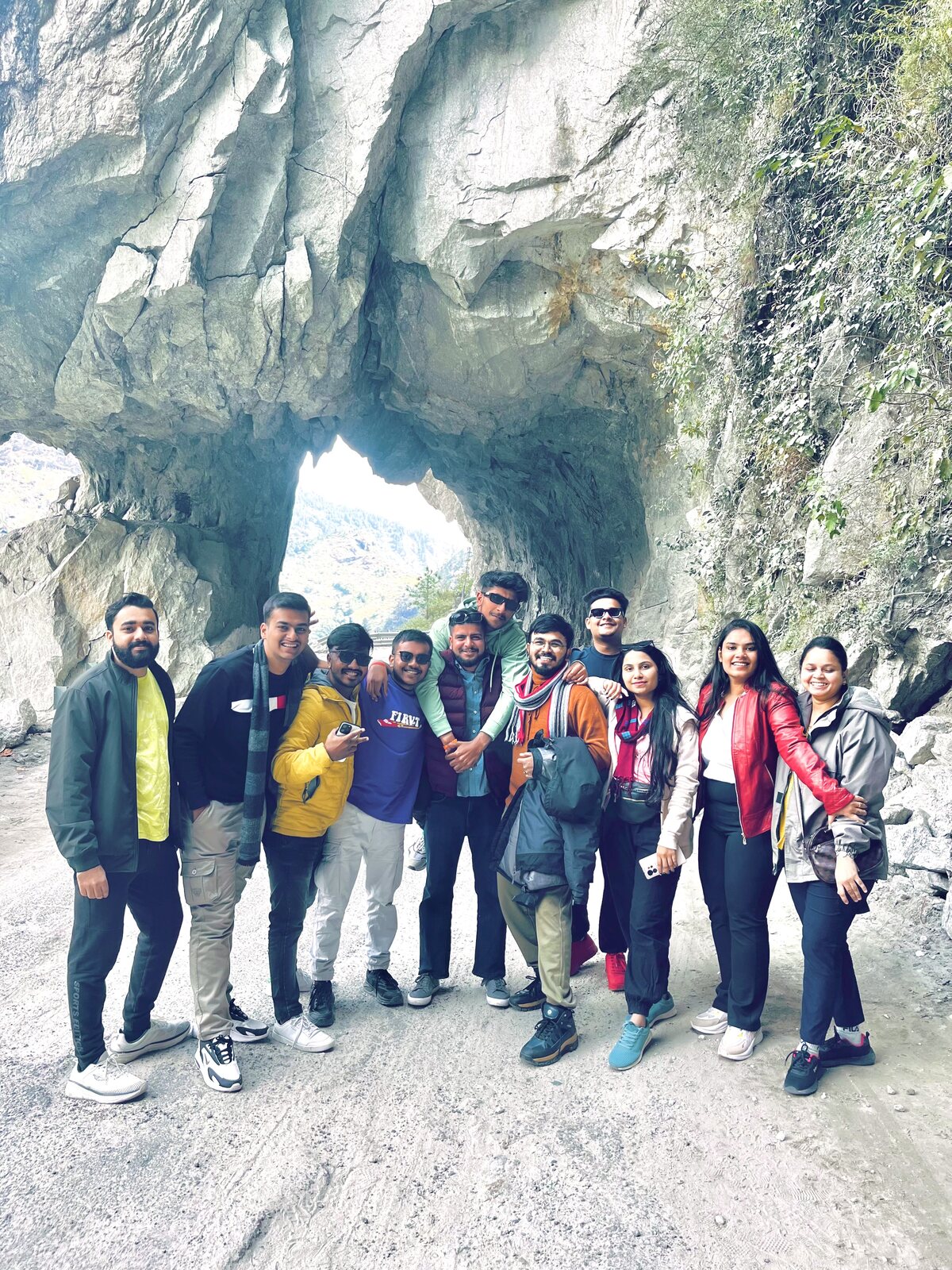 TRAVIA group posing under a rock tunnel on the mountain road